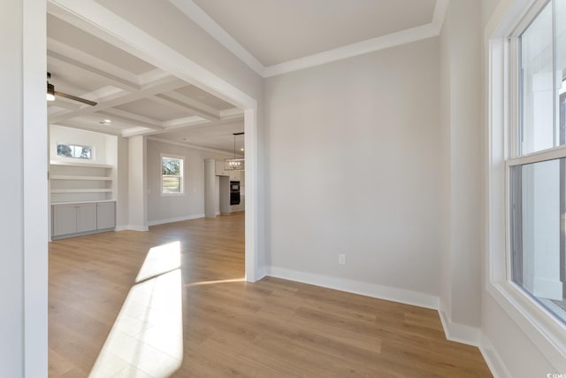 empty room with light wood finished floors, baseboards, ornamental molding, beam ceiling, and coffered ceiling