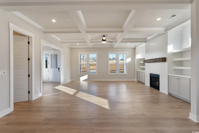 unfurnished living room featuring beamed ceiling, visible vents, coffered ceiling, a fireplace, and light wood finished floors