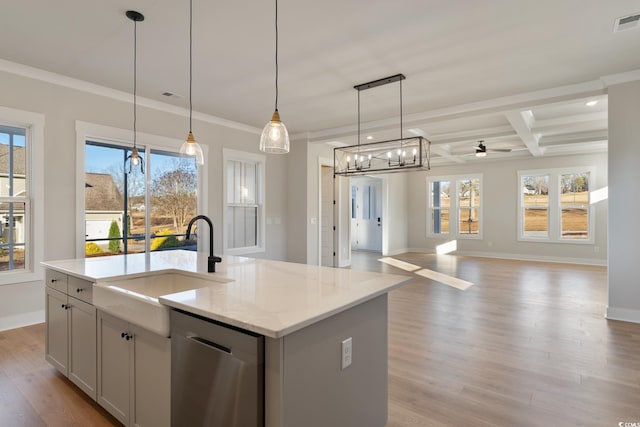 kitchen featuring a kitchen island with sink, light wood-style floors, dishwasher, decorative light fixtures, and open floor plan