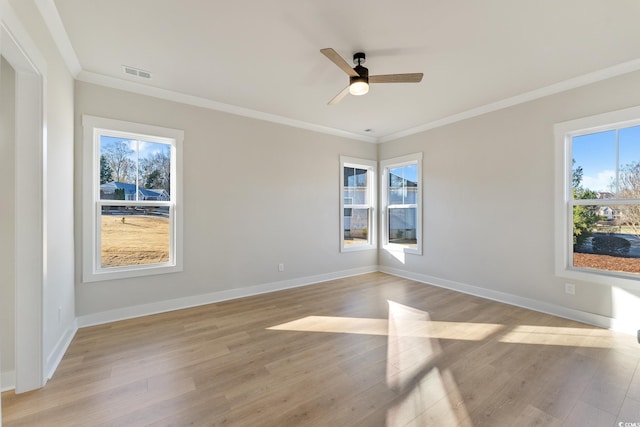 spare room with visible vents, crown molding, ceiling fan, baseboards, and light wood-type flooring