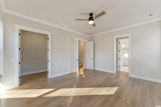 unfurnished bedroom with crown molding, visible vents, and light wood finished floors