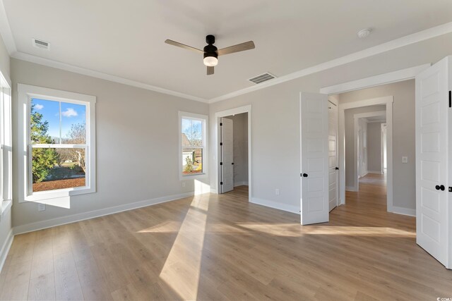 unfurnished bedroom featuring visible vents, baseboards, light wood-style flooring, and crown molding