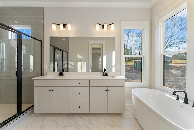 bathroom featuring a freestanding bath, a shower stall, marble finish floor, and a sink