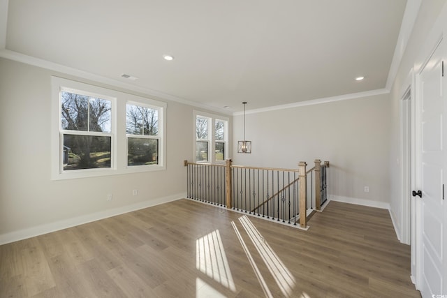 spare room featuring recessed lighting, wood finished floors, baseboards, and ornamental molding