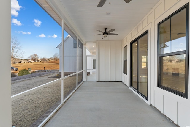 unfurnished sunroom featuring a ceiling fan and a healthy amount of sunlight