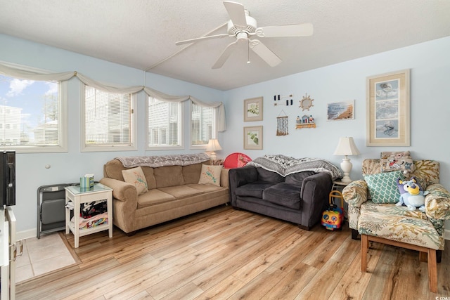 living area featuring light wood-style floors and a ceiling fan