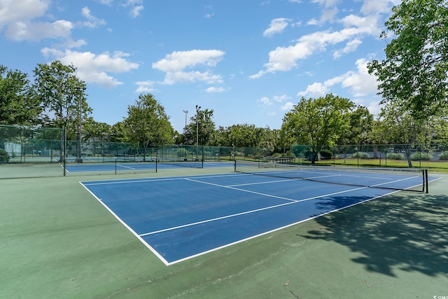 view of tennis court featuring fence and community basketball court