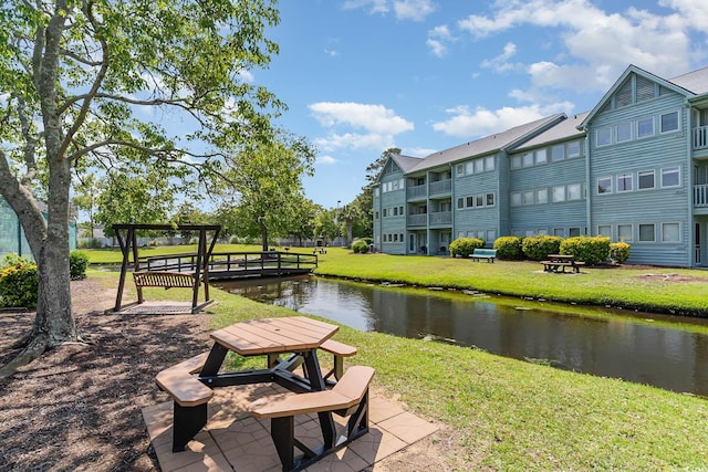 view of community featuring a yard and a water view