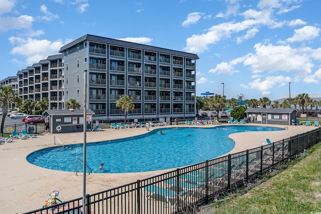 community pool featuring fence and a patio