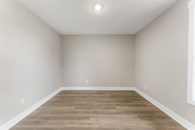 empty room featuring baseboards and wood finished floors