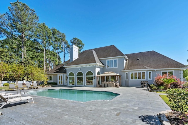 outdoor pool featuring a patio and area for grilling