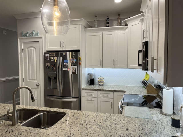 kitchen featuring electric range, a sink, black microwave, white cabinetry, and stainless steel fridge