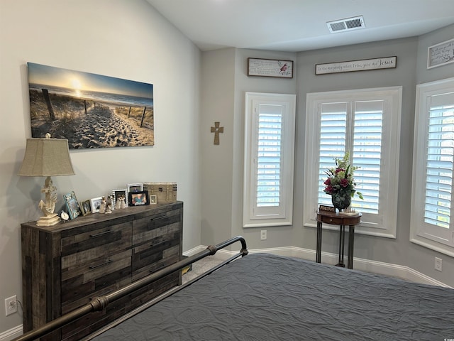 bedroom with multiple windows, baseboards, and visible vents