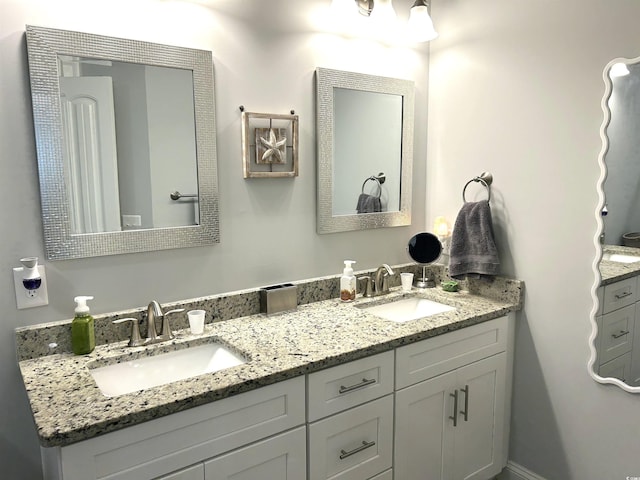 full bathroom featuring double vanity and a sink