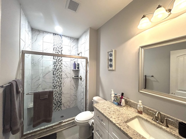 bathroom featuring vanity, toilet, visible vents, and a stall shower