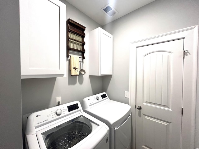 clothes washing area featuring cabinet space, visible vents, and washing machine and clothes dryer