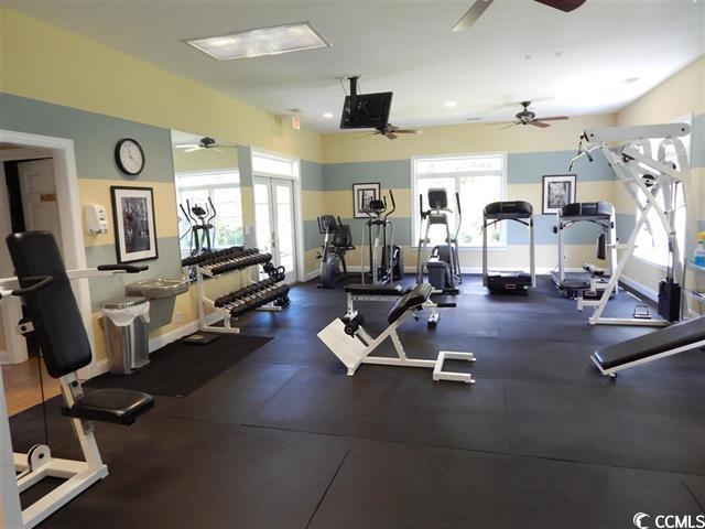 exercise room with baseboards and a ceiling fan