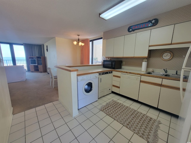 kitchen featuring black microwave, dishwasher, a peninsula, washer / clothes dryer, and a sink