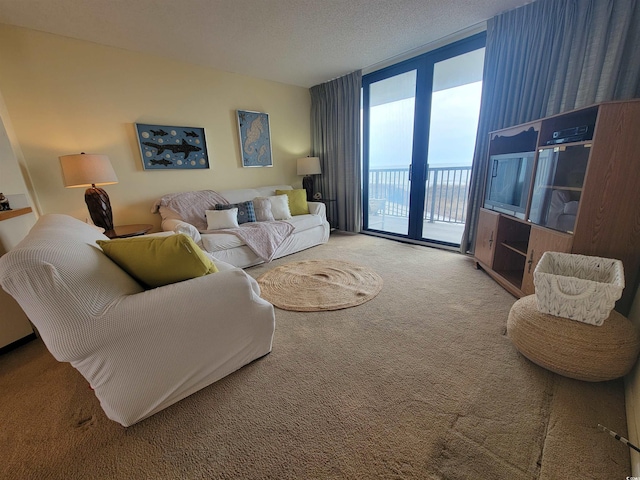 living room featuring carpet flooring, a textured ceiling, and a wall of windows