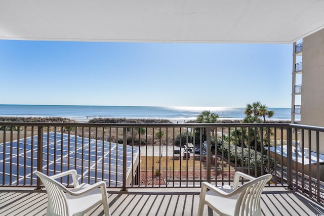 balcony with a water view and a beach view