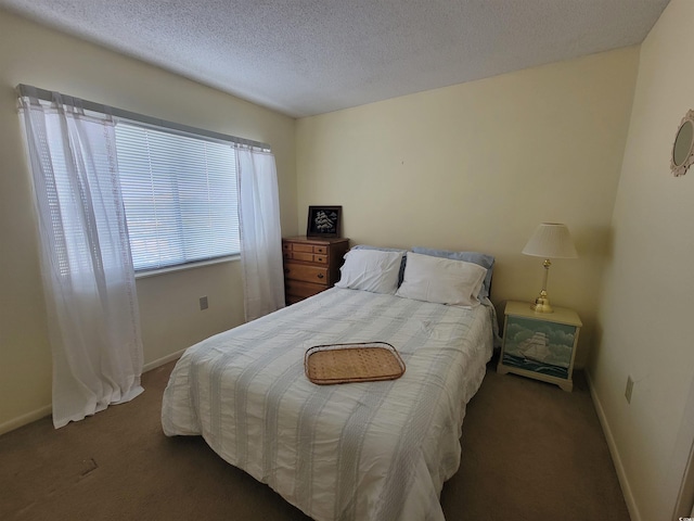 carpeted bedroom featuring a textured ceiling and baseboards