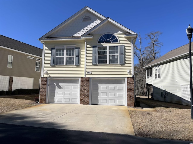 view of front of house featuring brick siding, an attached garage, and driveway