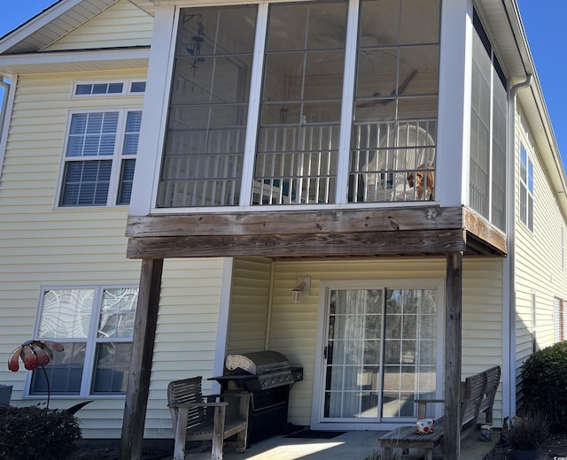 back of property featuring a patio, a balcony, and a sunroom