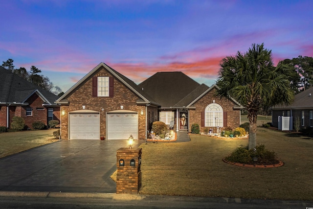 traditional home with concrete driveway, a garage, a lawn, and brick siding