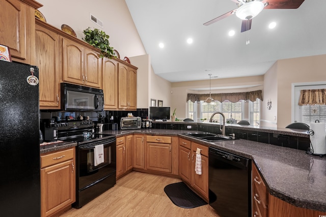 kitchen with visible vents, light wood-type flooring, a peninsula, black appliances, and a sink
