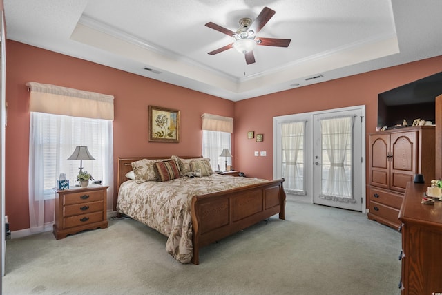 carpeted bedroom with a raised ceiling, access to exterior, and crown molding
