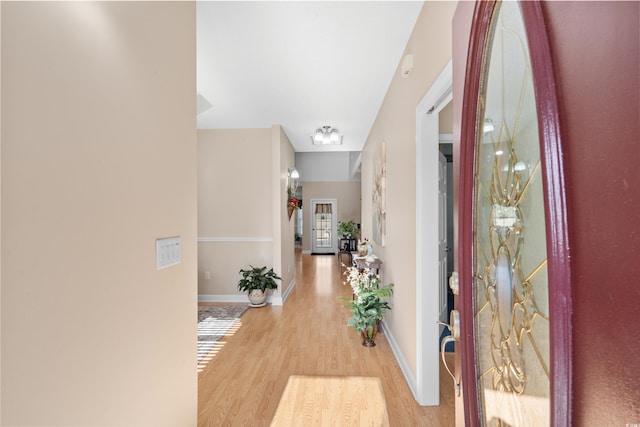 foyer with light wood-type flooring and baseboards