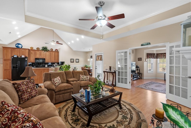 living area with high vaulted ceiling, light wood-style flooring, a ceiling fan, french doors, and crown molding