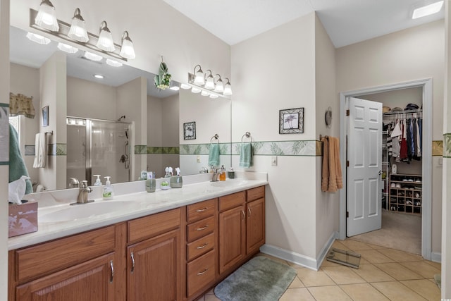 full bath featuring a sink, double vanity, a shower stall, and tile patterned floors