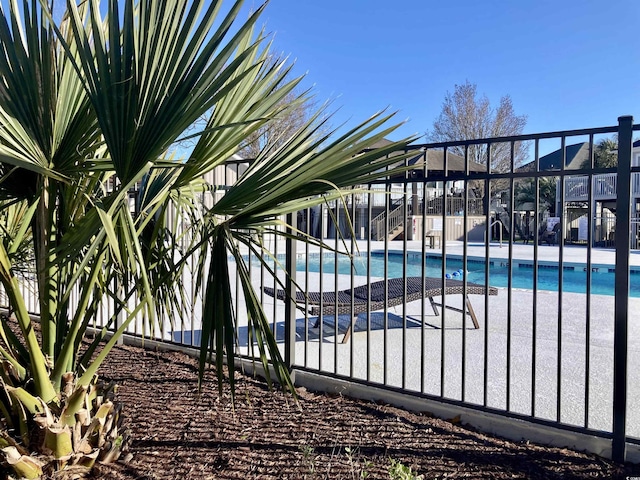 community pool with a patio and fence