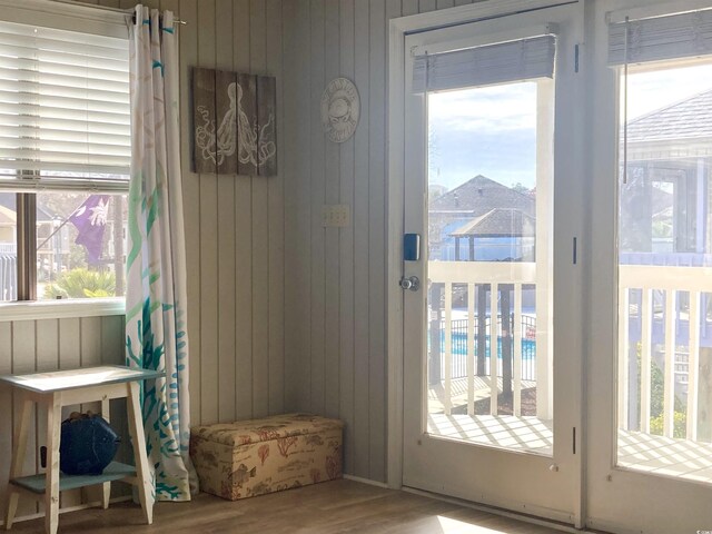 doorway featuring wooden walls and wood finished floors