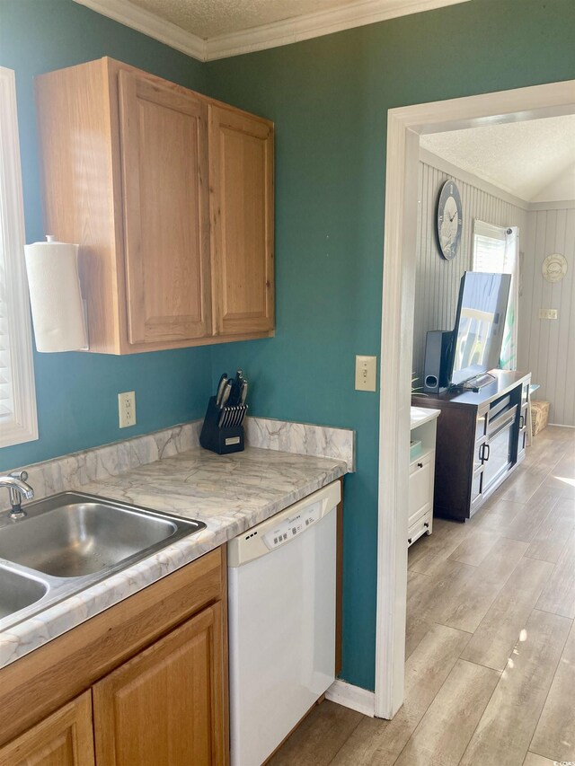 kitchen with crown molding, light wood-type flooring, light countertops, white dishwasher, and a sink