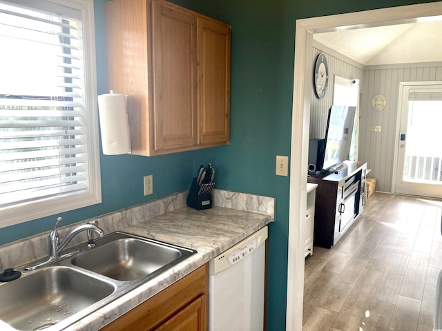 kitchen featuring light wood-type flooring, white dishwasher, a sink, light countertops, and brown cabinets