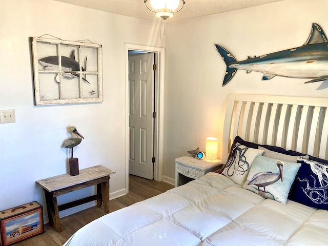 bedroom featuring wood finished floors and baseboards