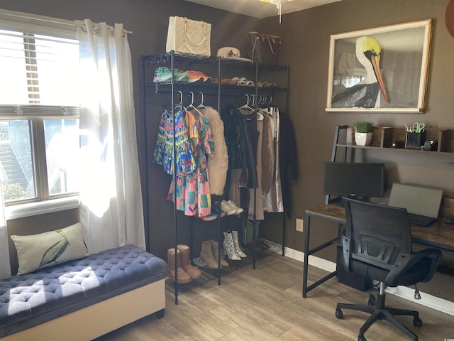 office with baseboards, a healthy amount of sunlight, and wood finished floors