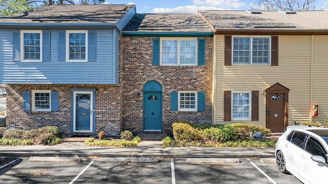 townhome / multi-family property with uncovered parking and brick siding