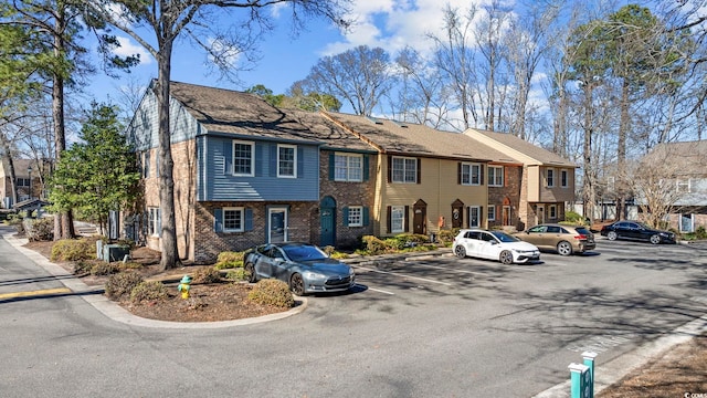 view of front of property with brick siding and uncovered parking