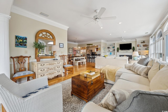 living room with built in features, wood finished floors, recessed lighting, ceiling fan, and crown molding