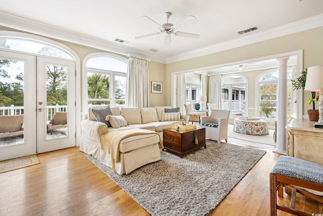 sunroom featuring ornate columns, visible vents, french doors, and a ceiling fan