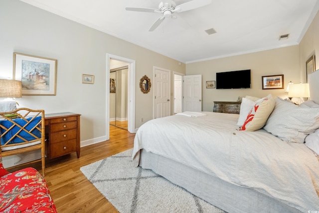 bedroom with baseboards, visible vents, ceiling fan, crown molding, and light wood-type flooring