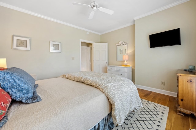 bedroom with baseboards, a ceiling fan, wood finished floors, and crown molding