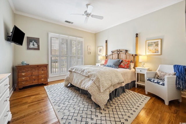 bedroom featuring visible vents, a ceiling fan, light wood-style flooring, and crown molding