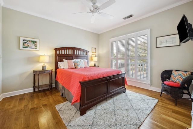 bedroom featuring visible vents, baseboards, and wood finished floors