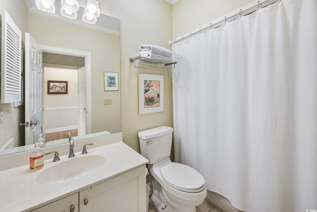 bathroom featuring toilet, vanity, and crown molding