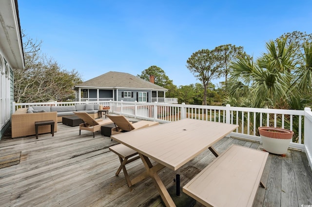 wooden terrace with outdoor dining area and outdoor lounge area