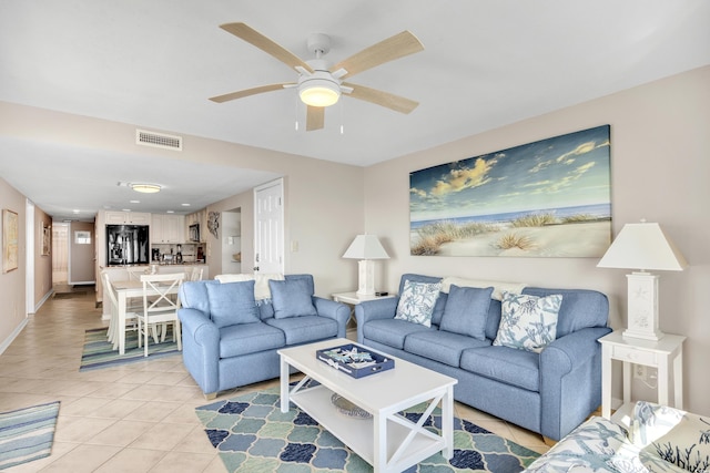 living area with a ceiling fan, light tile patterned floors, baseboards, and visible vents